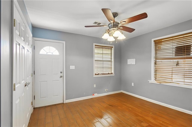 foyer entrance featuring hardwood / wood-style floors, a wealth of natural light, and ceiling fan