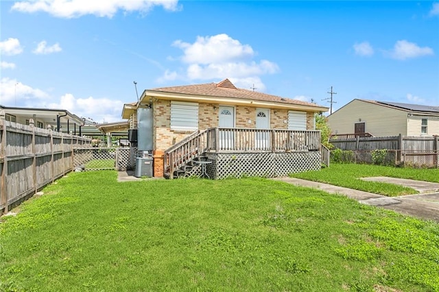 rear view of property with a deck and a lawn