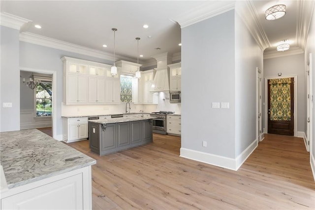 kitchen featuring appliances with stainless steel finishes, a kitchen island, white cabinetry, and light hardwood / wood-style flooring