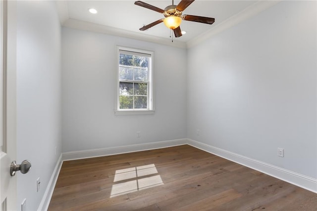 empty room featuring dark wood-type flooring, crown molding, and ceiling fan