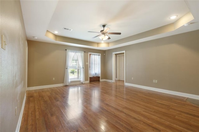 spare room featuring ceiling fan, a tray ceiling, and hardwood / wood-style floors