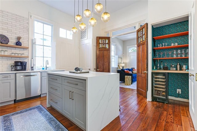 kitchen with stainless steel dishwasher, gray cabinetry, a center island, wine cooler, and hanging light fixtures