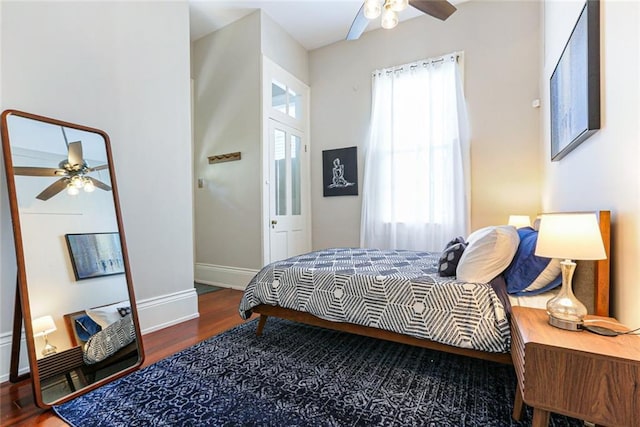 bedroom with hardwood / wood-style flooring, ceiling fan, and multiple windows