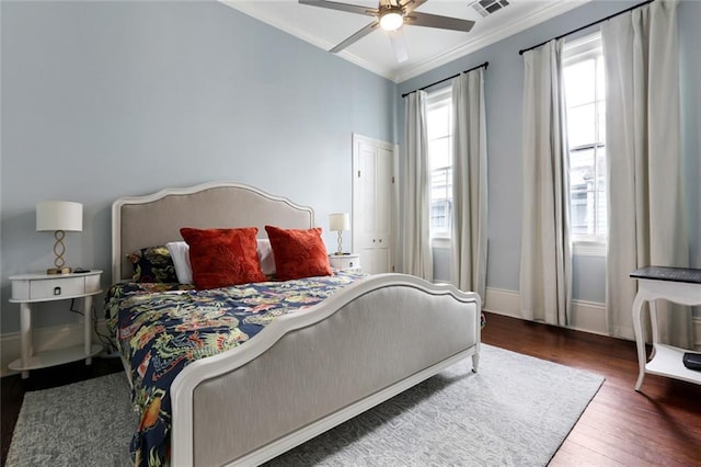 bedroom with ceiling fan, dark hardwood / wood-style flooring, and ornamental molding