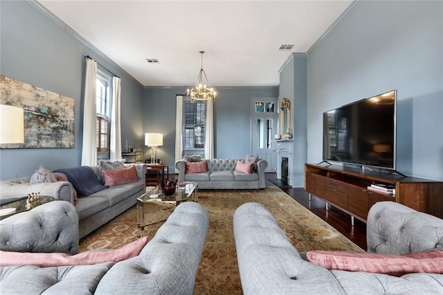 living room with crown molding, dark hardwood / wood-style floors, and a notable chandelier