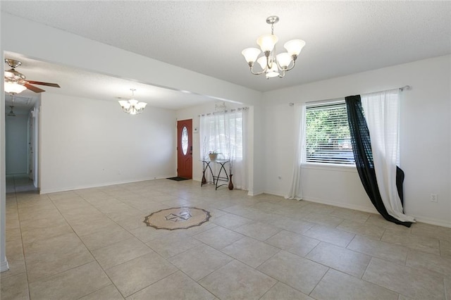 unfurnished room featuring light tile patterned floors and ceiling fan with notable chandelier