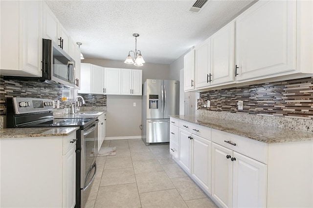 kitchen featuring tasteful backsplash, white cabinetry, stainless steel appliances, and a notable chandelier