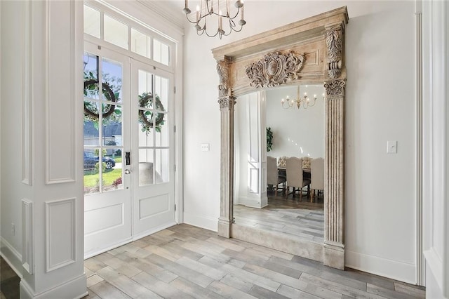 entryway with wood-type flooring and a notable chandelier