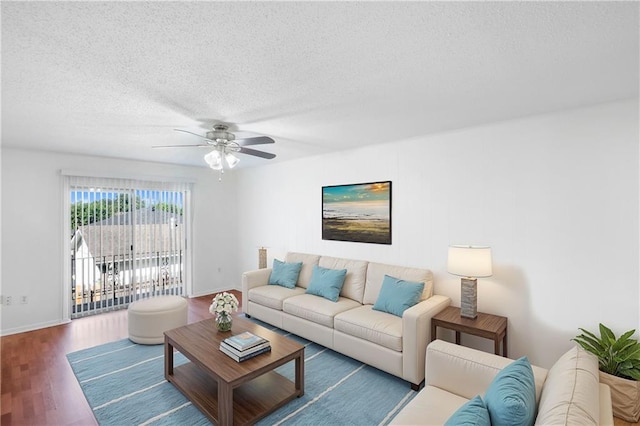 living room with ceiling fan, hardwood / wood-style floors, and a textured ceiling