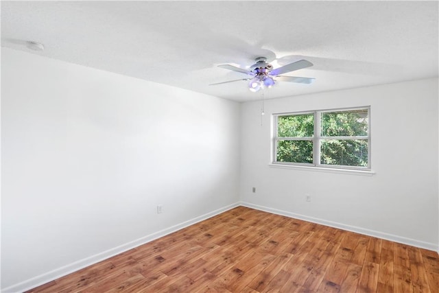 spare room featuring wood-type flooring and ceiling fan