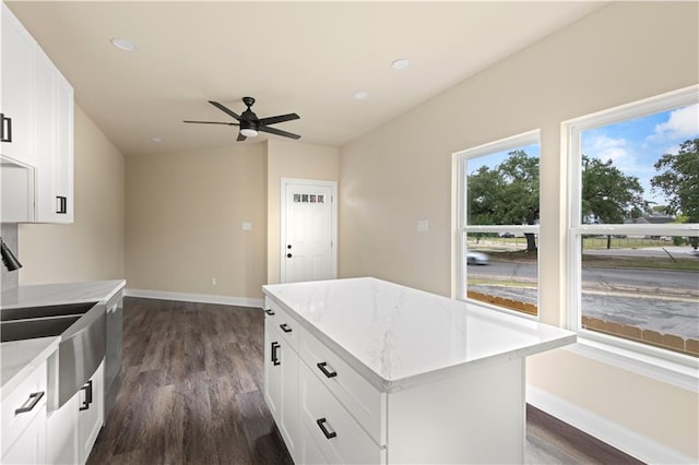 kitchen featuring dark wood-type flooring, white cabinets, sink, and a center island