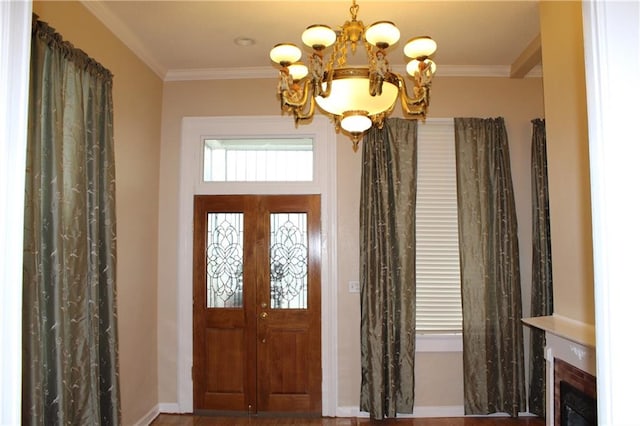 foyer with crown molding and a chandelier