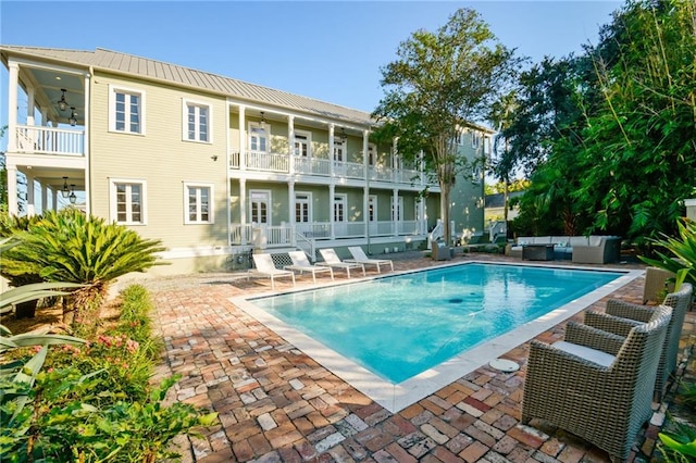 view of swimming pool with a fenced in pool, a patio area, an outdoor living space, and a ceiling fan