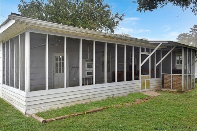 view of property exterior featuring a yard and a sunroom