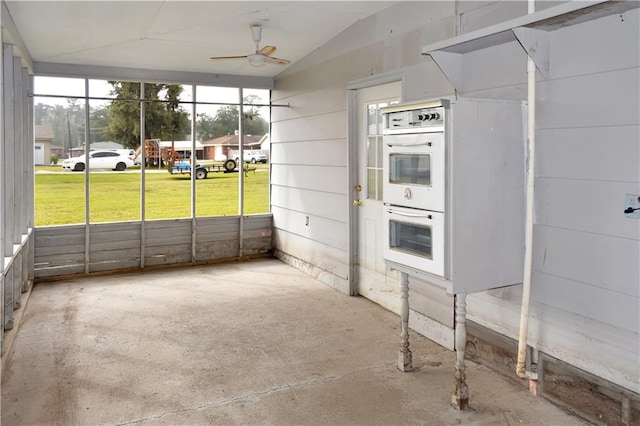 kitchen featuring ceiling fan, double oven, and concrete flooring