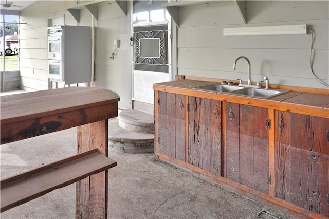 kitchen featuring tile countertops, white double oven, and sink