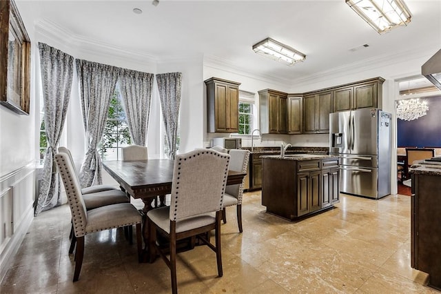 dining space featuring crown molding, a chandelier, and plenty of natural light