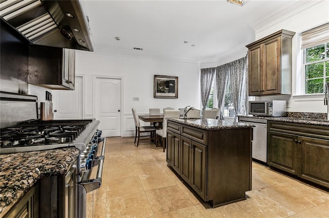 kitchen featuring plenty of natural light, ventilation hood, appliances with stainless steel finishes, and dark stone counters