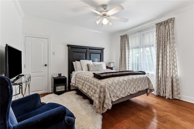 bedroom featuring ceiling fan, crown molding, and hardwood / wood-style floors