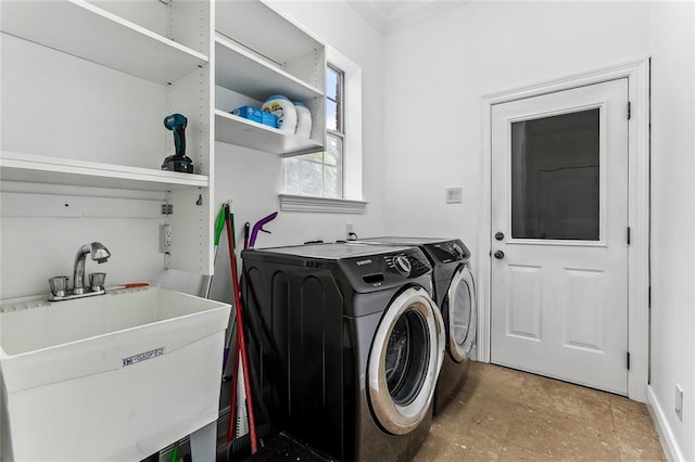 washroom with ornamental molding, washer and dryer, and sink