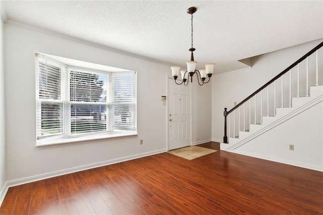 entryway featuring a notable chandelier, a textured ceiling, and hardwood / wood-style floors