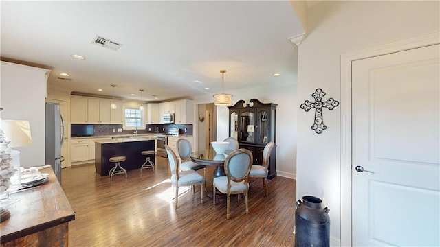 dining room featuring crown molding and dark wood-type flooring