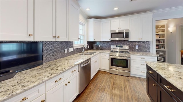 kitchen with light hardwood / wood-style floors, stainless steel appliances, sink, and white cabinetry