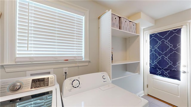 laundry area featuring washer and dryer and light tile patterned floors