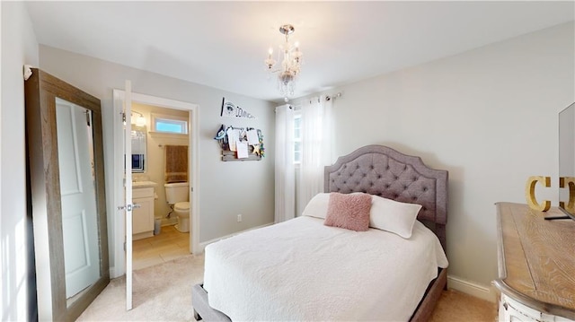 carpeted bedroom with ensuite bath and an inviting chandelier