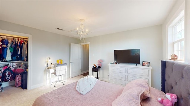 carpeted bedroom featuring a closet and an inviting chandelier