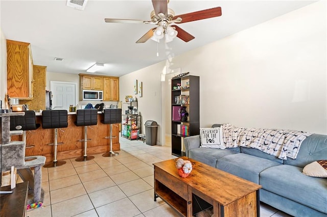 tiled living room featuring ceiling fan