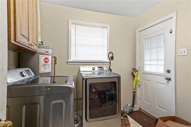 laundry area with water heater, separate washer and dryer, light tile patterned floors, and cabinets