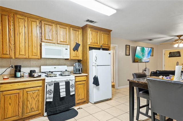 kitchen with ceiling fan, white appliances, light tile patterned floors, and backsplash