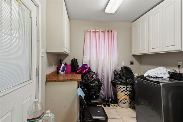 washroom with washer / clothes dryer, cabinets, and light tile patterned floors