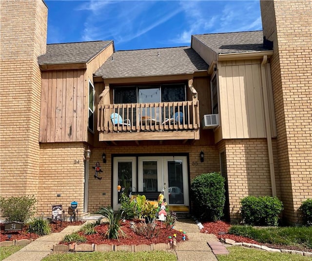 view of front of property featuring cooling unit and a balcony