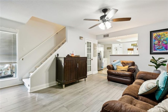 living room with light wood-type flooring and ceiling fan