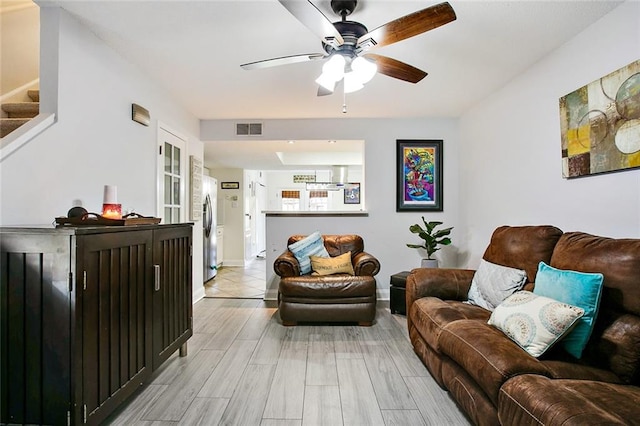 living room with light hardwood / wood-style flooring and ceiling fan