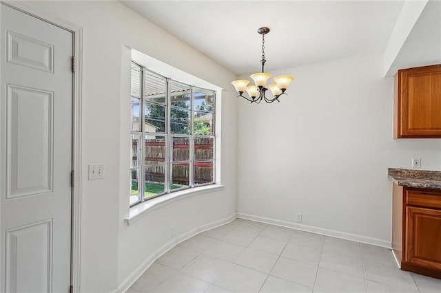 unfurnished dining area with a chandelier and light tile patterned floors