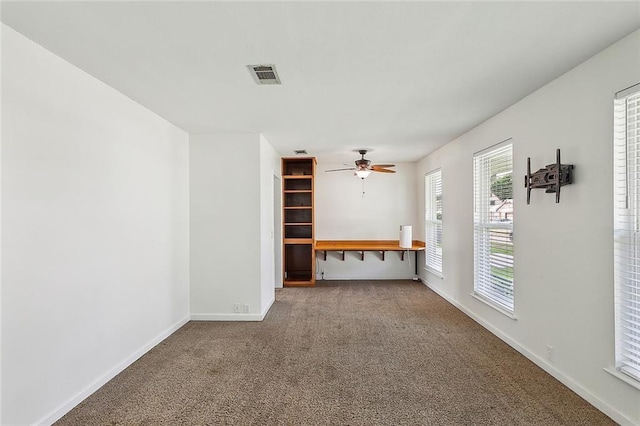 unfurnished living room featuring carpet and ceiling fan