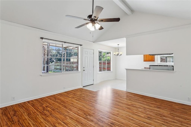 unfurnished living room with ceiling fan with notable chandelier, vaulted ceiling with beams, light hardwood / wood-style flooring, and plenty of natural light