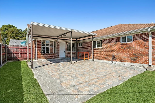 rear view of property with a lawn and a patio area