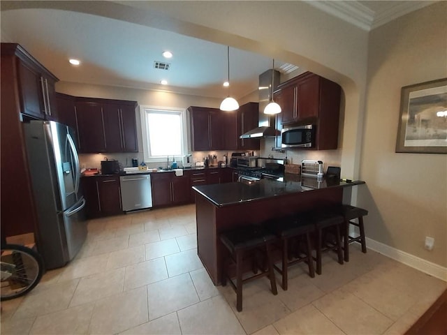 kitchen with ornamental molding, island range hood, decorative light fixtures, stainless steel appliances, and a breakfast bar