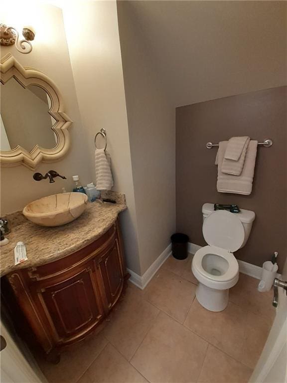 bathroom with toilet, tile patterned flooring, and vanity