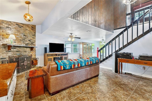 living room featuring ceiling fan and a brick fireplace