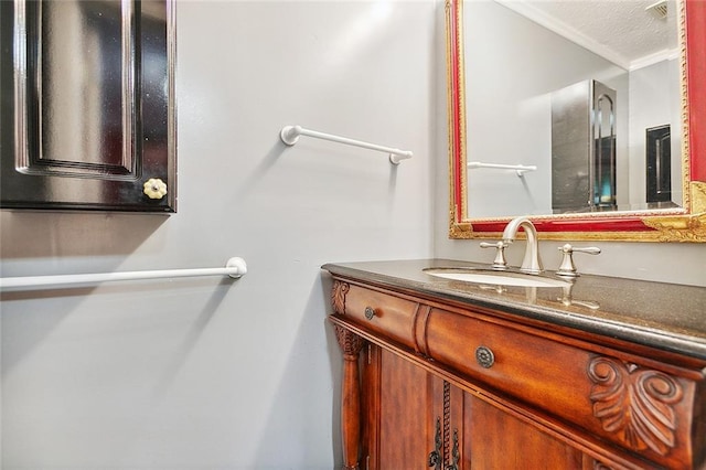 bathroom with vanity, ornamental molding, and a textured ceiling