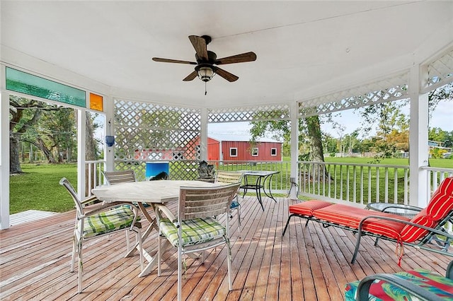 wooden terrace featuring a yard and ceiling fan