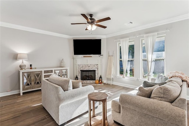 living room featuring dark wood-type flooring, crown molding, and ceiling fan