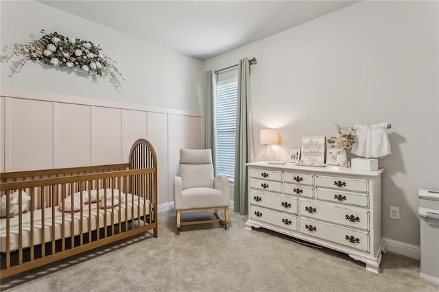 carpeted bedroom featuring a nursery area