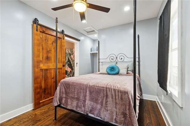 bedroom featuring ceiling fan, a closet, a barn door, and wood-type flooring