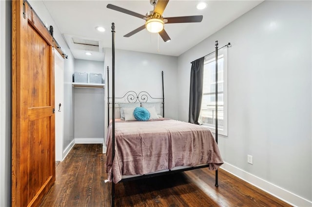 bedroom featuring ceiling fan, a barn door, and dark hardwood / wood-style flooring